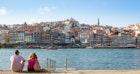 A couple of people - a man and a woman are sitting together on the South side of Douro river in Porto, Portugal. On the other side of the river is the historic center of Porto, acknowledged by the UNESCO as the World Heritage Site.
641434798