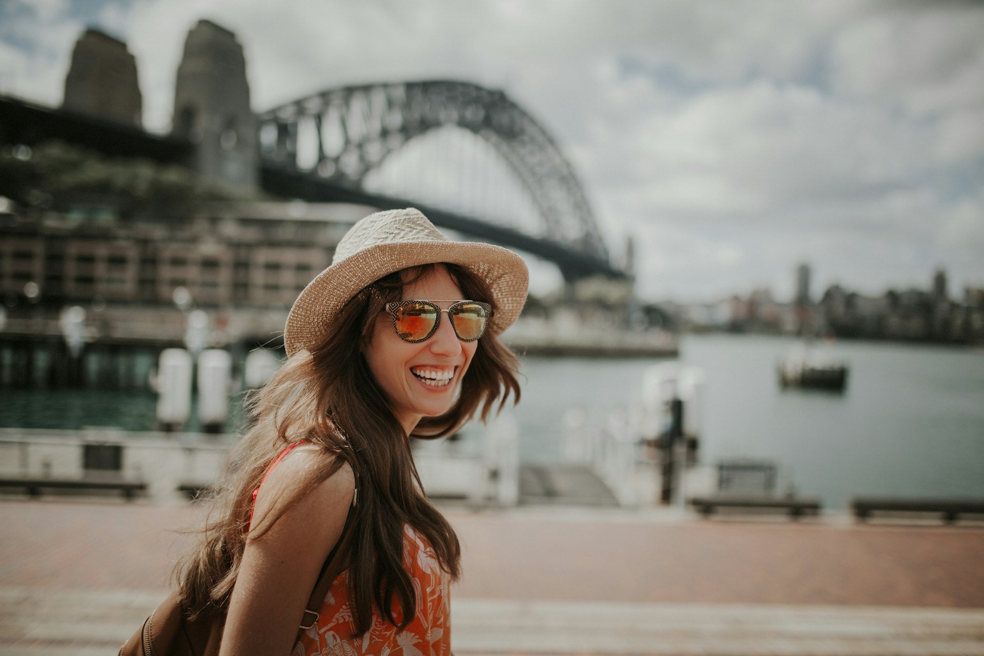 Happy smiling woman exploring Sydney, with Harbour Bridge in the background