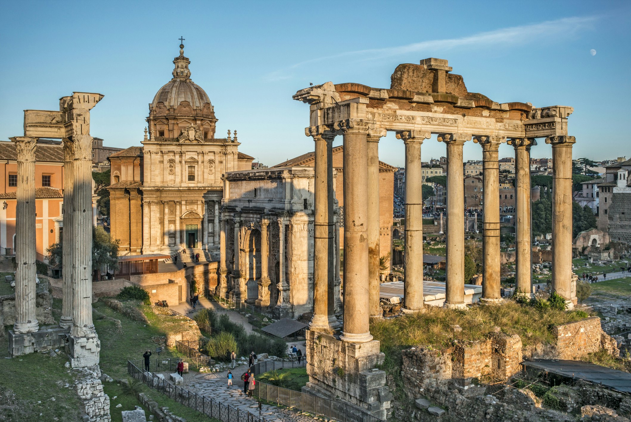 Visitors gather at the foot of ancient monuments in the Forum in Rome.