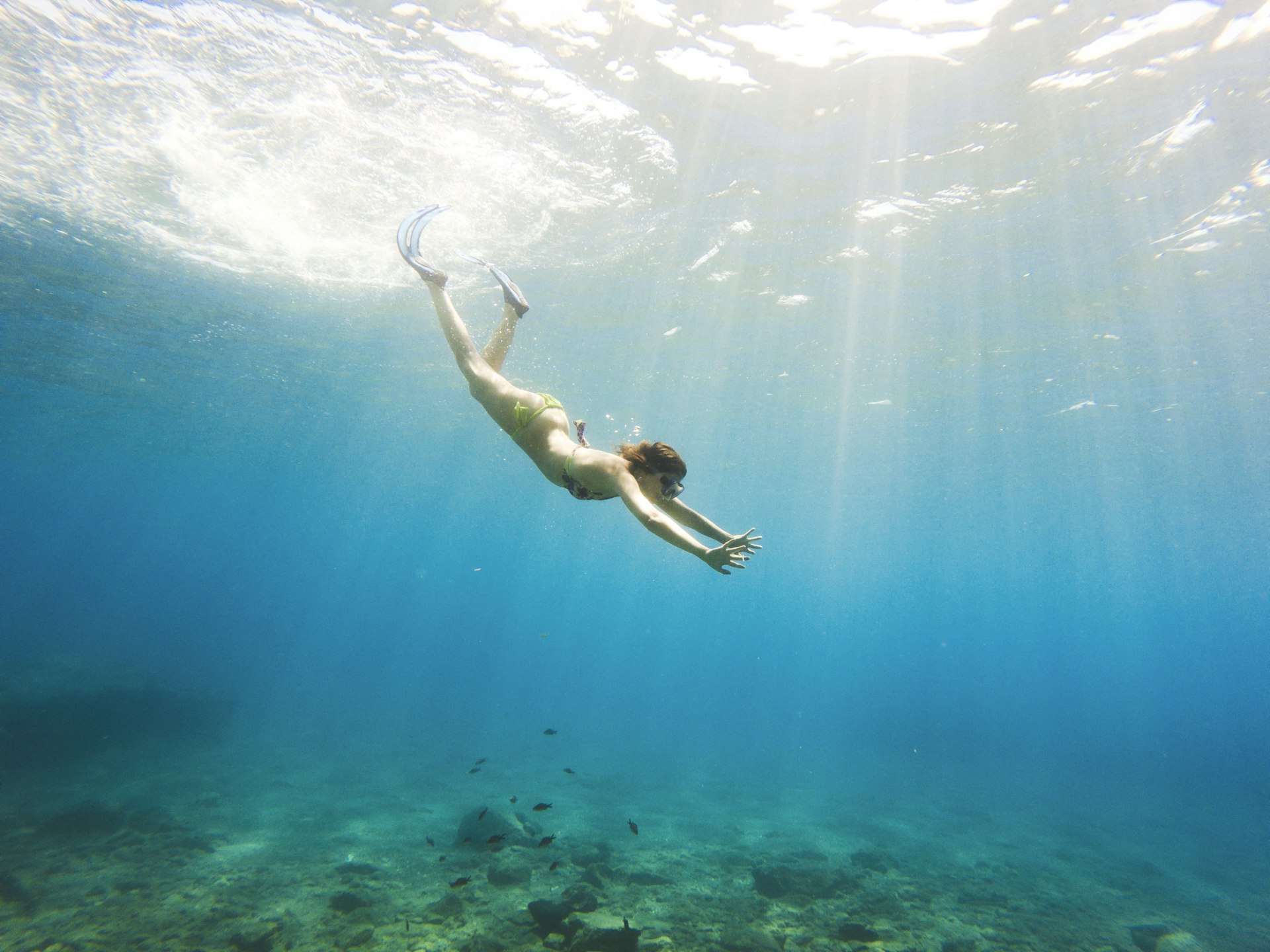 Stunning photograph of a young woman diving in the deep and crystalline waters of the Cyclades islands, Milos,
