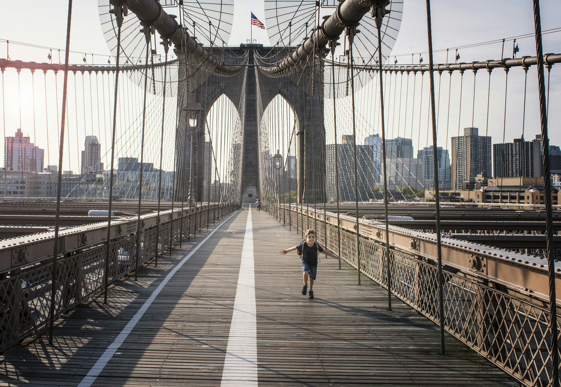 Boy running on Brooklyn Bridge,  New York City