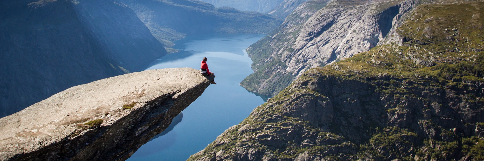Sitting on Trolltunga rock overlooking the fjord.