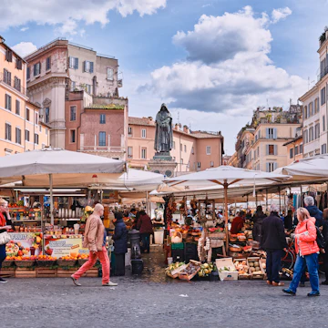 March 8, 2018: Traditional outdoor food market of Campo de Fiori (fields of flower), with the statue of Giordano Bruno in the background.
959994236
People Built Structure Food City History Architecture Nature Vacations Square Horizontal Three Quarter Length Outdoors Europe Tourist Monument Roman Italy Statue City Street Street Market - Retail Space Ancient Famous Place Rome - Italy Vegetable Fruit Flower Sky Agricultural Field Beauty Medium Group Of People Photography Tourism Travel Capital Cities Fiori Giordano Tradition