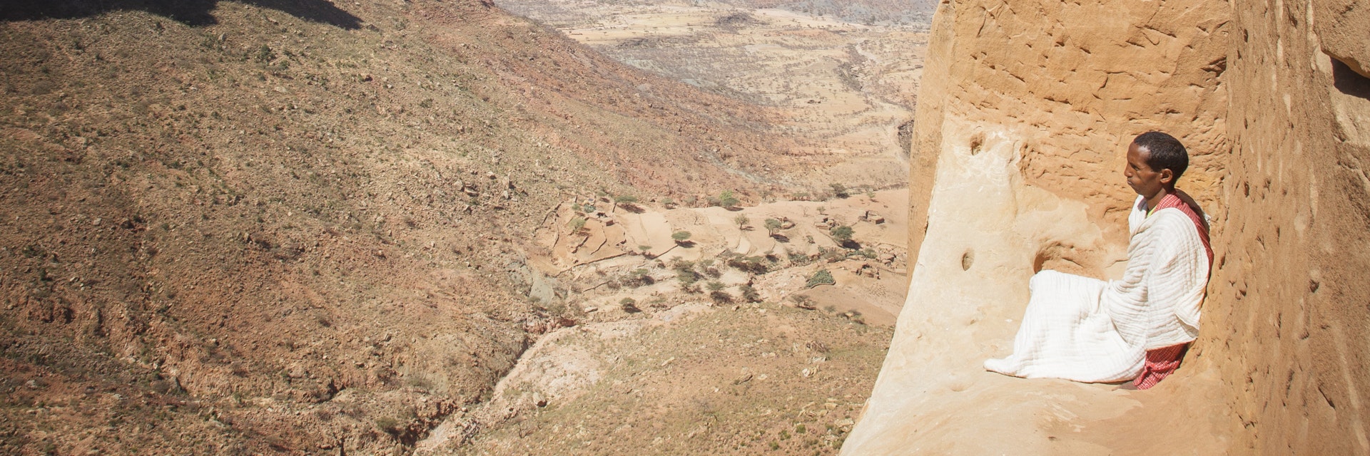Lonely Planet Traveller Magazine, Issue 66, Ethiopia, In the beginning
Priest sitting on ledge outside Abuna Yemata Guh cave church.