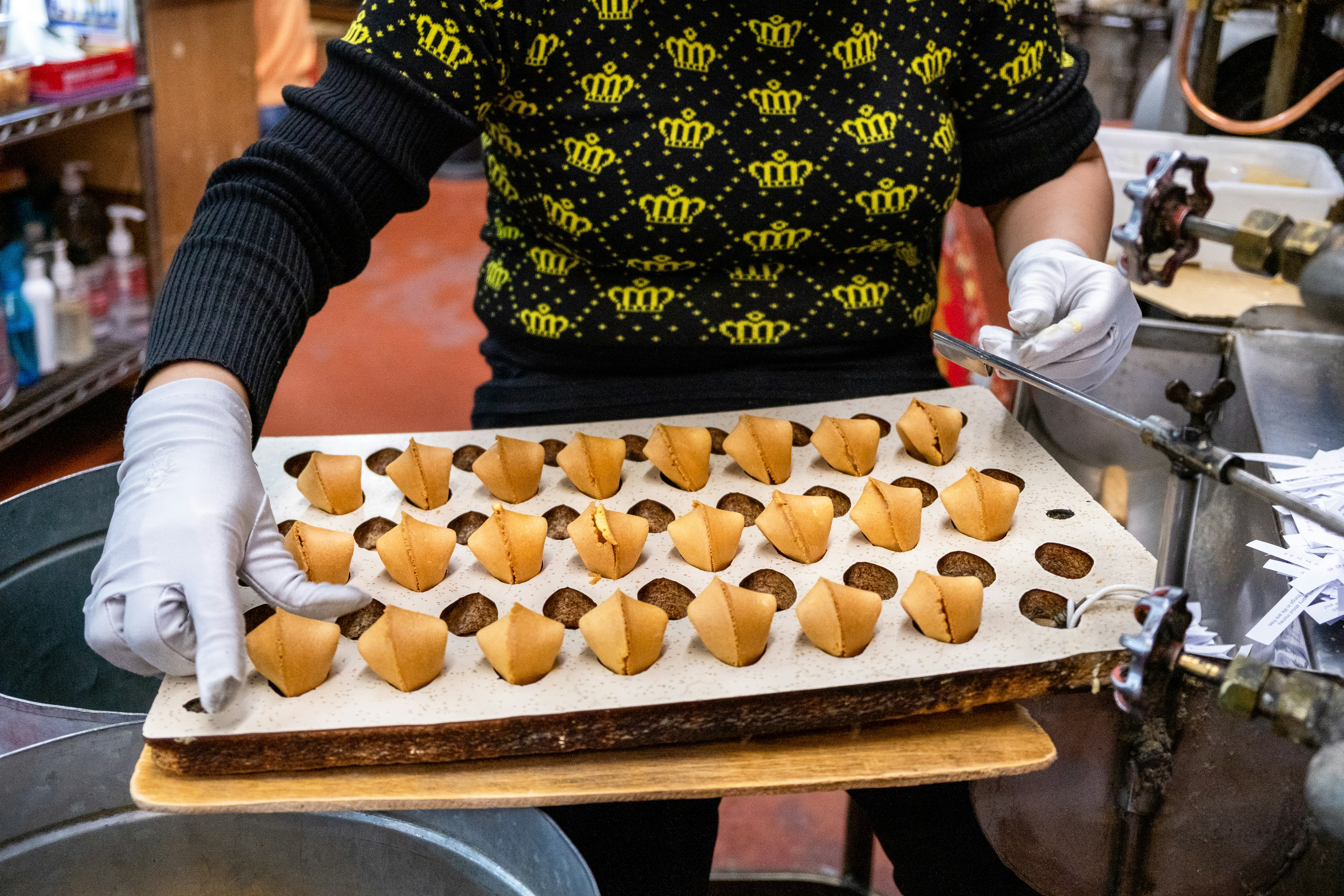 Staff member holding a tray of fortune cookies