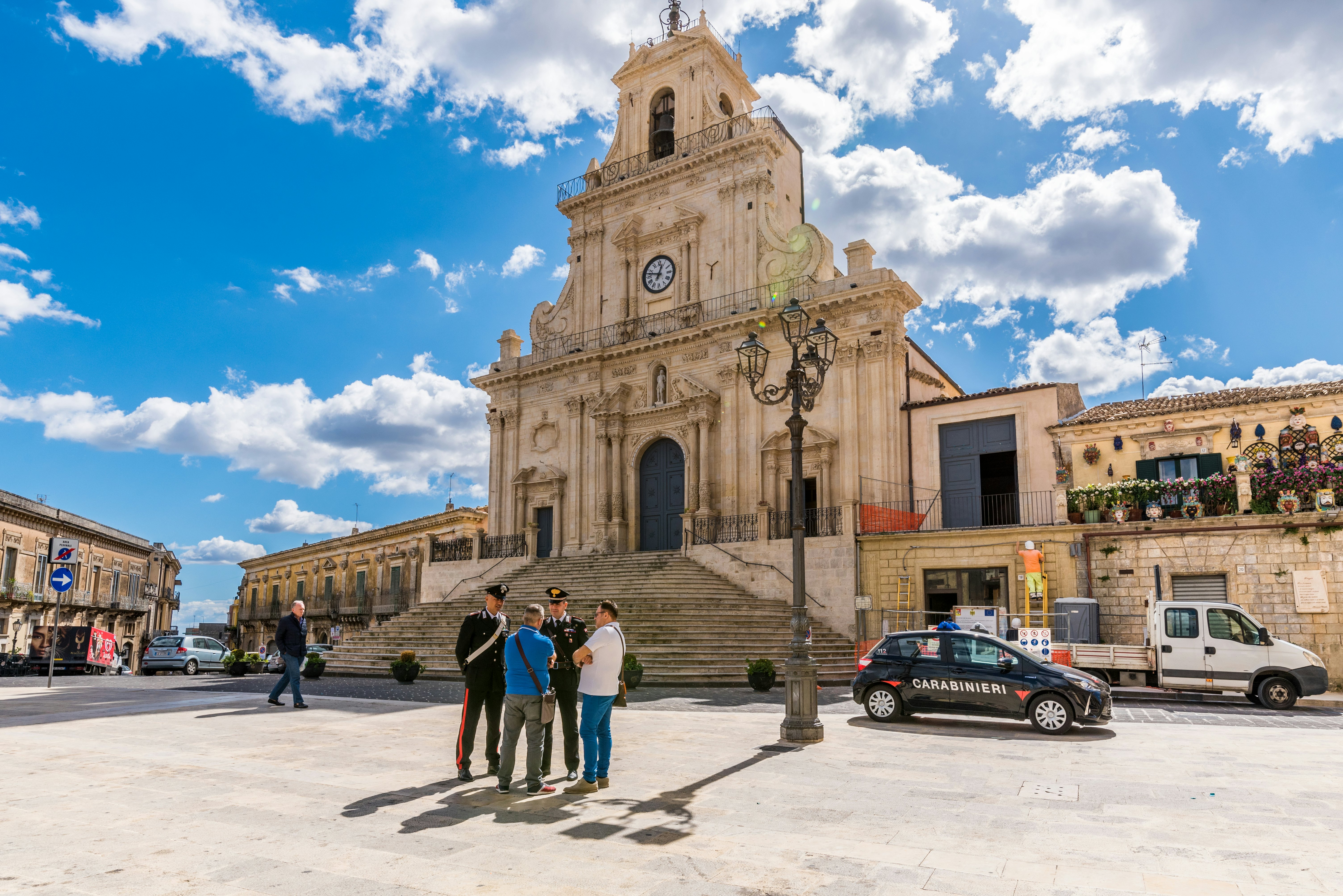 Palazzolo Acreide/ Syracuse Sicily/ Italy - october 04 2019: Two Carabinieri speak and give information to some tourists, on the steps in front of the cathedral of Palazzolo Acreide
1181168446
shops, attraction, baroque, bell tower, building, columns, cops, dome, exterior, flight of steps, heritage, historic, outdoor, police, style, temple, tourists, upright, windows, cars, police man, lamp, palazzolo, clouds, benemerita, square