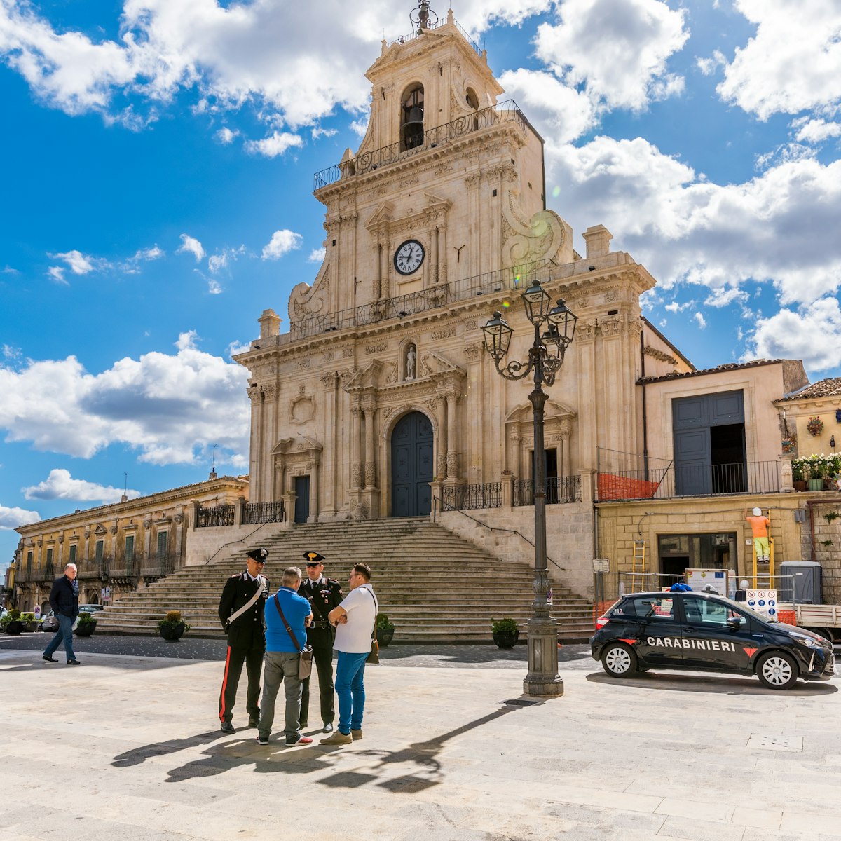 Palazzolo Acreide/ Syracuse Sicily/ Italy - october 04 2019: Two Carabinieri speak and give information to some tourists, on the steps in front of the cathedral of Palazzolo Acreide
1181168446
shops, attraction, baroque, bell tower, building, columns, cops, dome, exterior, flight of steps, heritage, historic, outdoor, police, style, temple, tourists, upright, windows, cars, police man, lamp, palazzolo, clouds, benemerita, square
