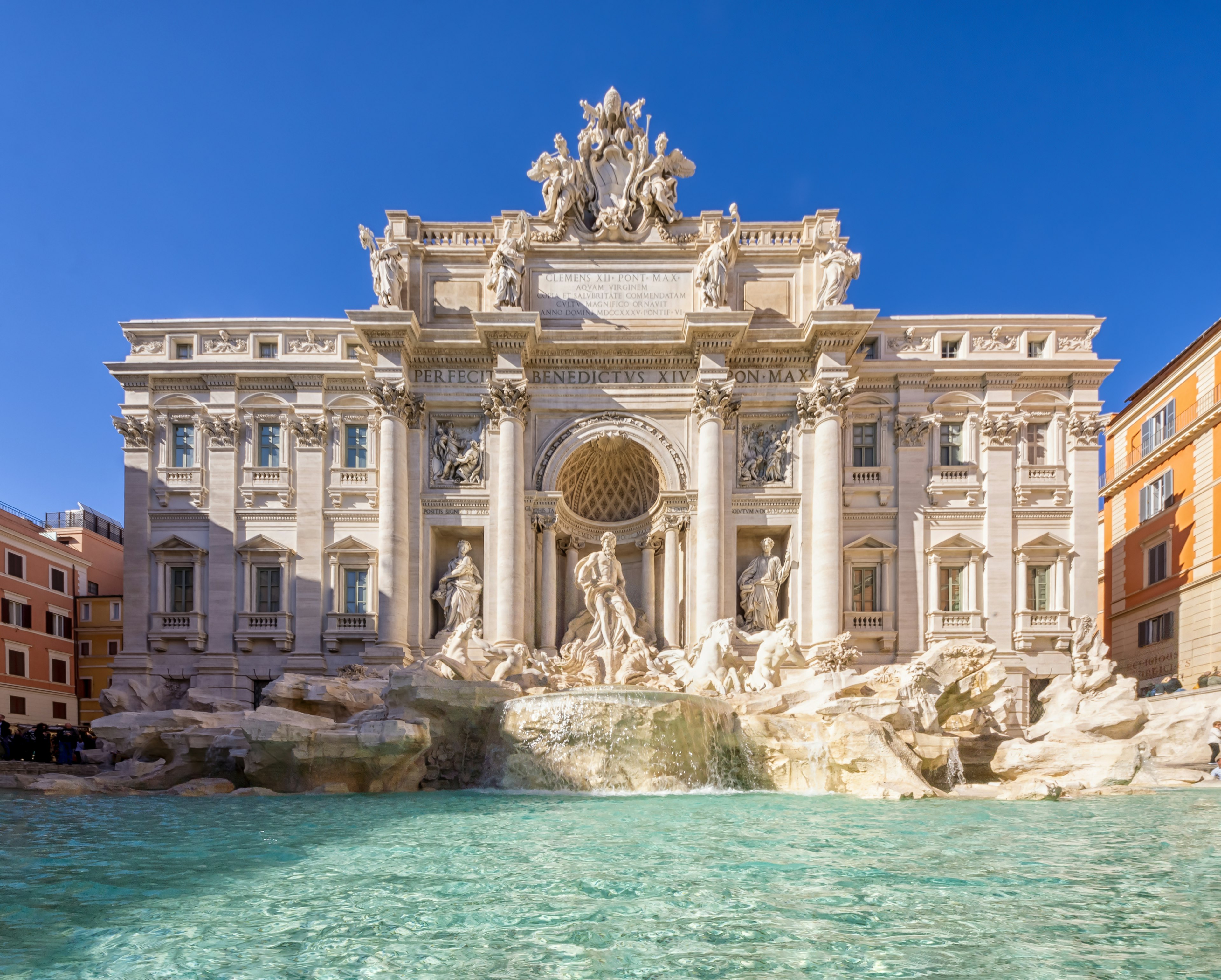 The blue waters of Trevi Fountain are backed by the grandiose Baroque sculptures and mansion-like facade