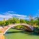 Stone Devil bridge across water canal on Torcello island, embankment promenade along water canal, green trees, tower and blue sky background. Venetian Lagoon, Veneto Region, Northern Italy.
1224140496
region, italia, populated, sparsely
