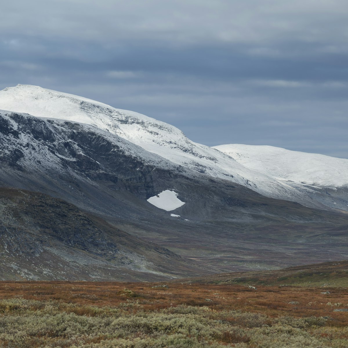 Dusting of autumn snow covers Ammarfjället mountains in Vindelfjällen nature reserve from Kungsleden Trail, Lapland, Sweden.