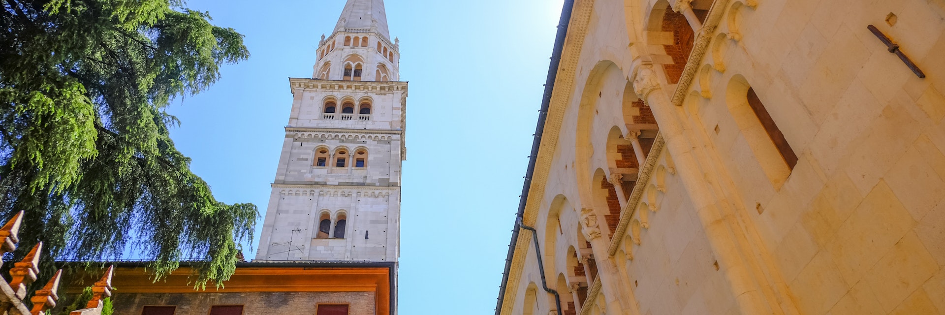 May 2022 Modena, Italy: Tower Ghirlandina and the facade of the Duomo Modena across the blue sky from beneath on the square piazza della Torre on a sunny day
1396874400
la ghirlandina, torre, marble, dome, duomo di modena, from beneath, building, square, piazza della torre, travel destination, blu sky, sunny day, flags, historic, culture, buildings, urban, exterior, stone, view, landmark