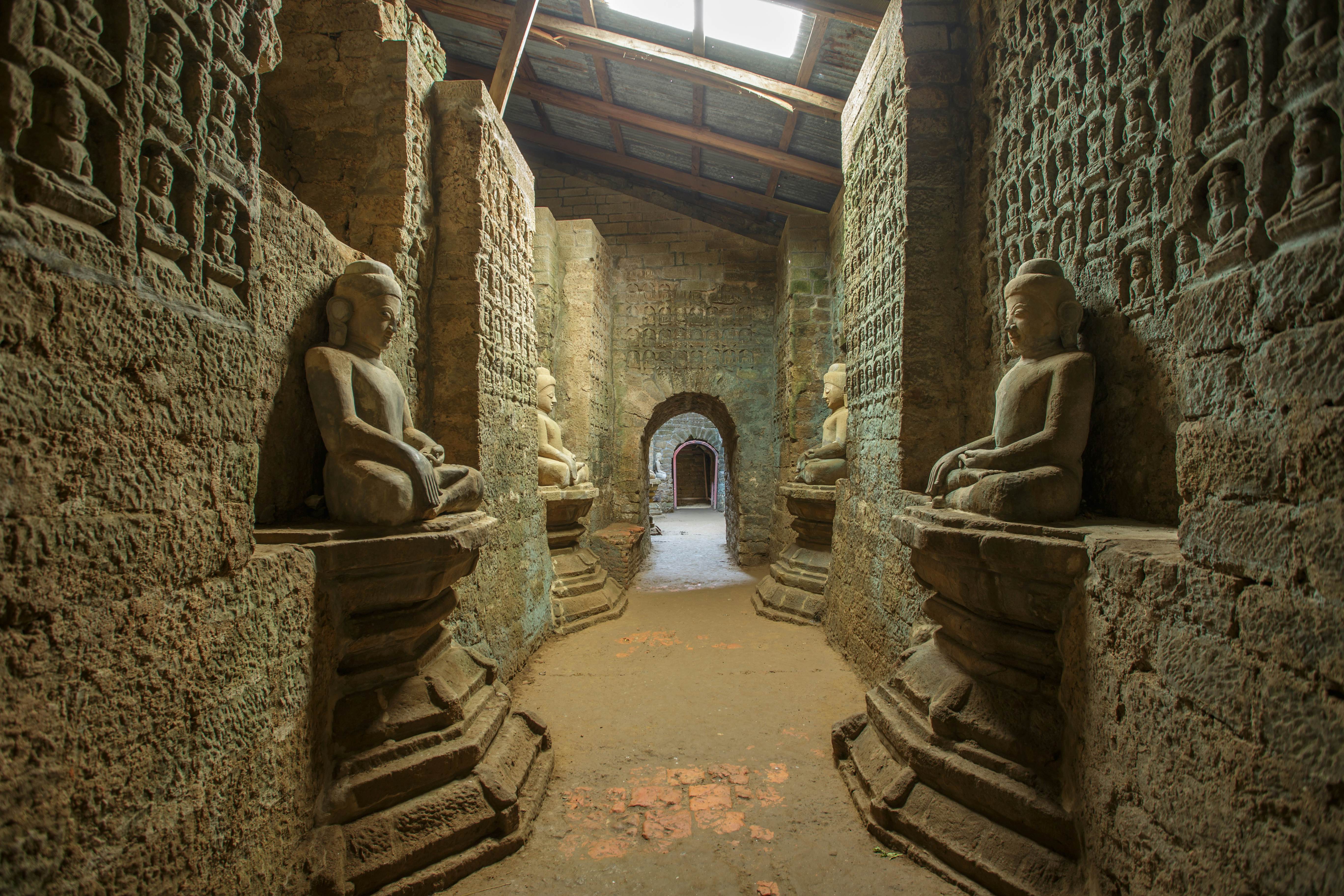 Tunnel with ancient Buddha statues in Kothaung Paya temple in Mrauk-U city, Rakhine state, Myanmar.