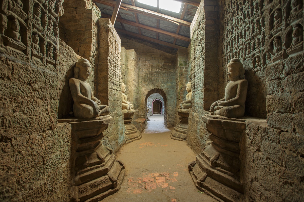 Tunnel with ancient Buddha statues in Kothaung Paya temple in Mrauk-U city, Rakhine state, Myanmar.