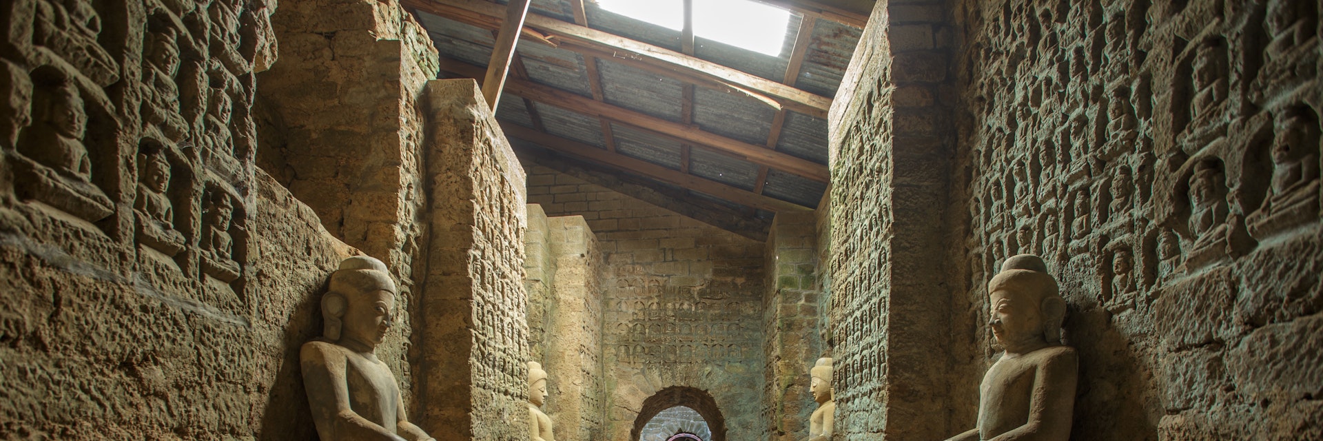 Tunnel with ancient Buddha statues in Kothaung Paya temple in Mrauk-U city, Rakhine state, Myanmar.