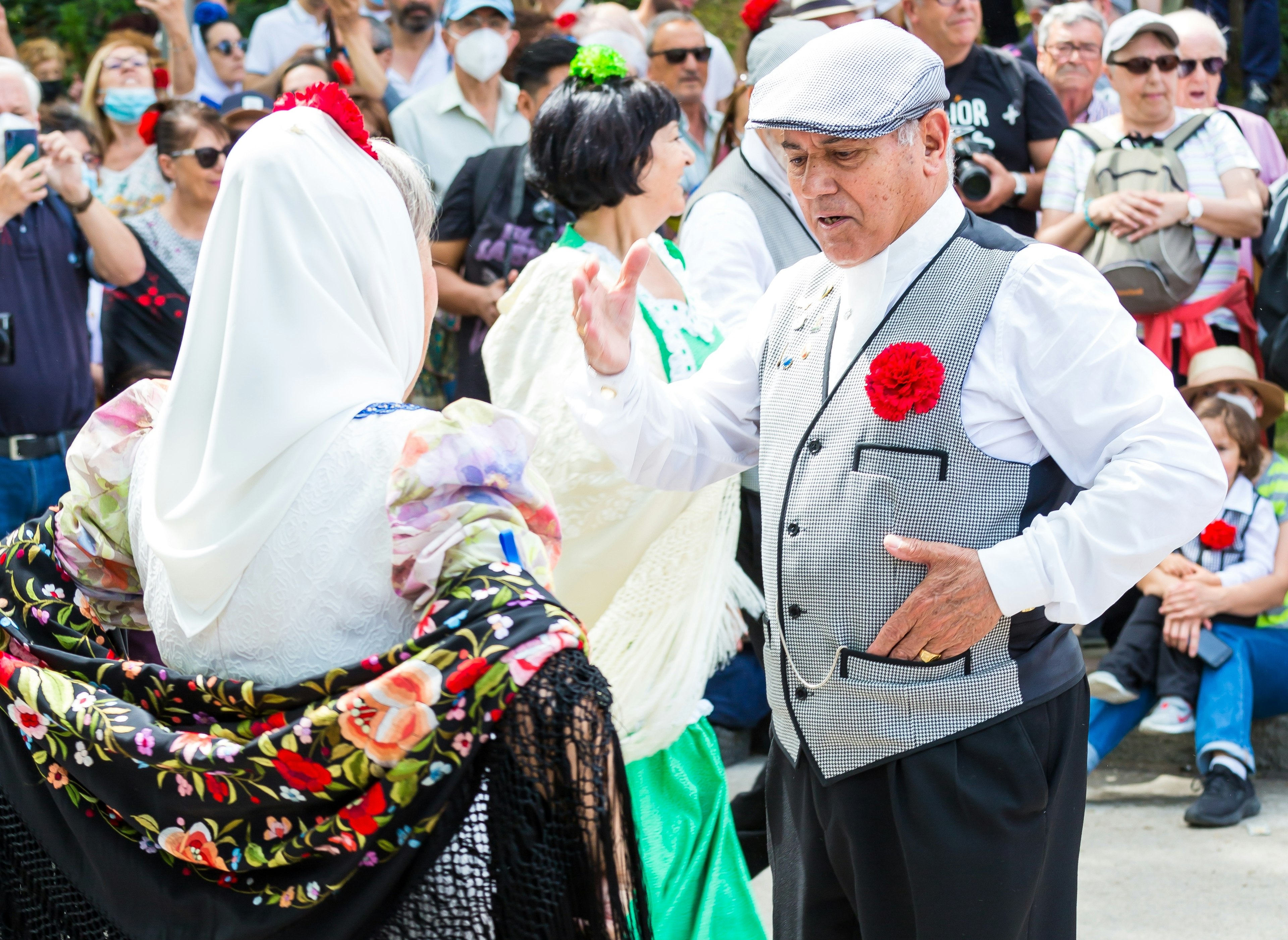 Two people in traditional dress perform a dance during a festival