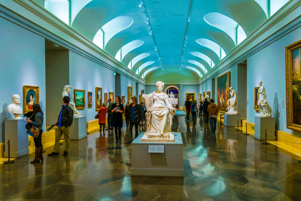 Masterpieces in the Prado, Madrid People walk through a crowded art gallery