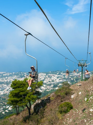 July 29, 2018: People riding up the mountain chair lift in Capri.
1158732217
above, adventure, aerial, amalfi, anacapri, cable, cableway, campania, capri, car, chair, chairlift, city, destination, europe, funicular, height, high, island, italian, italy, landscape, lift, mediterranean, monte, mount, mountain, naples, nature, people, sea, sky, solaro, summer, top, tour, tourism, tourist, touristic, town, transport, transportation, travel, trip, vacation, view, way