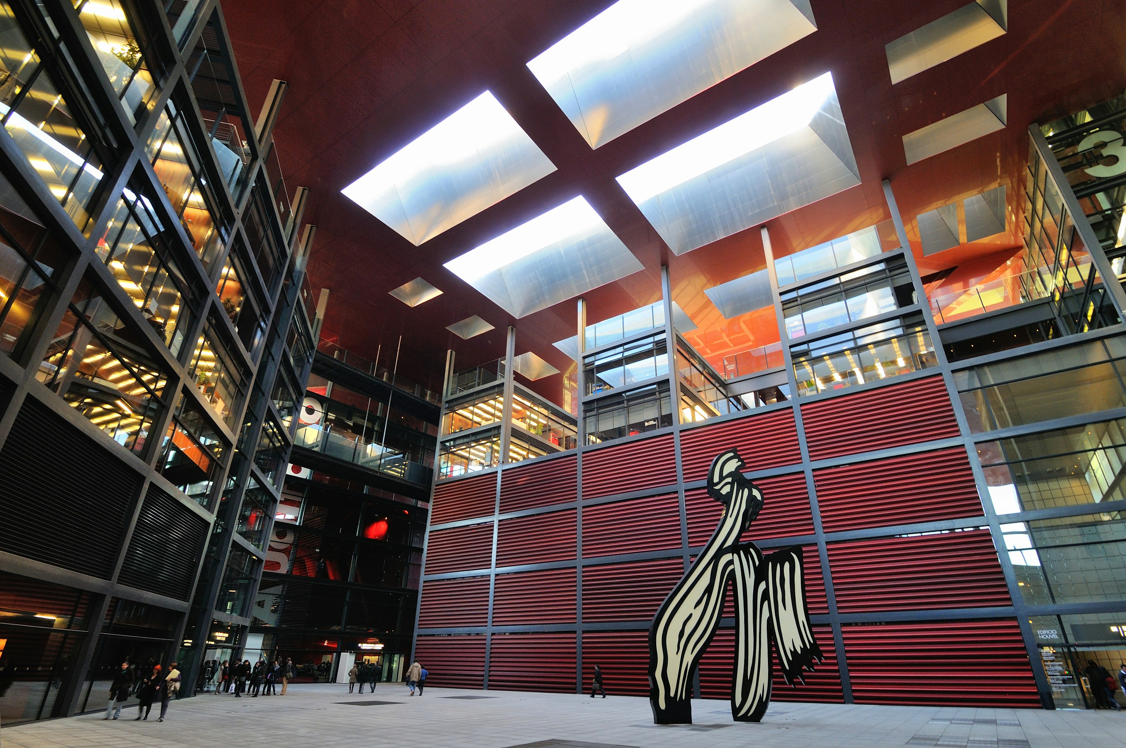 People in the interior courtyard of Madrid's Reina Sofia museum, looking at a tall black-and-white Roy Lichtenstein sculpture