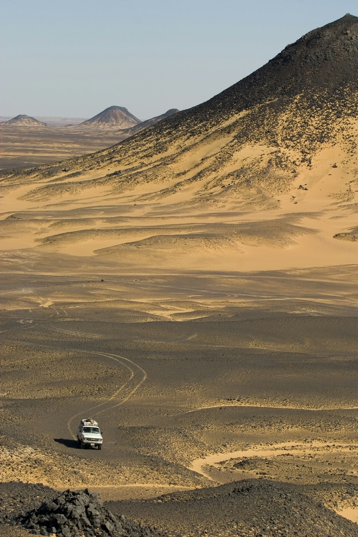 A 4x4 drives through the black desert in Egypt.