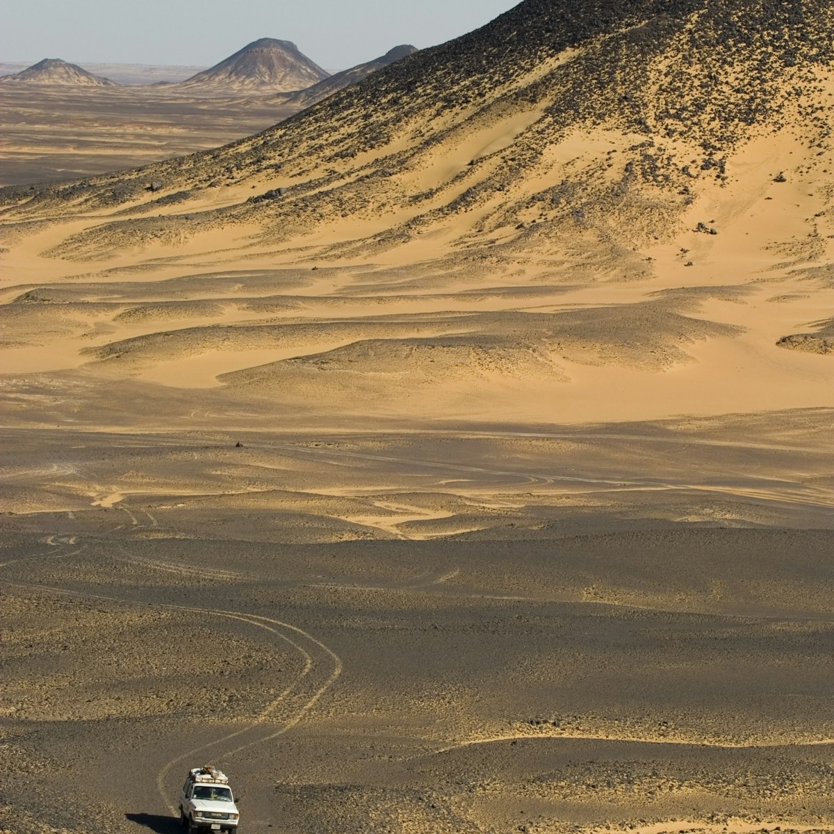 A 4x4 drives through the black desert in Egypt.