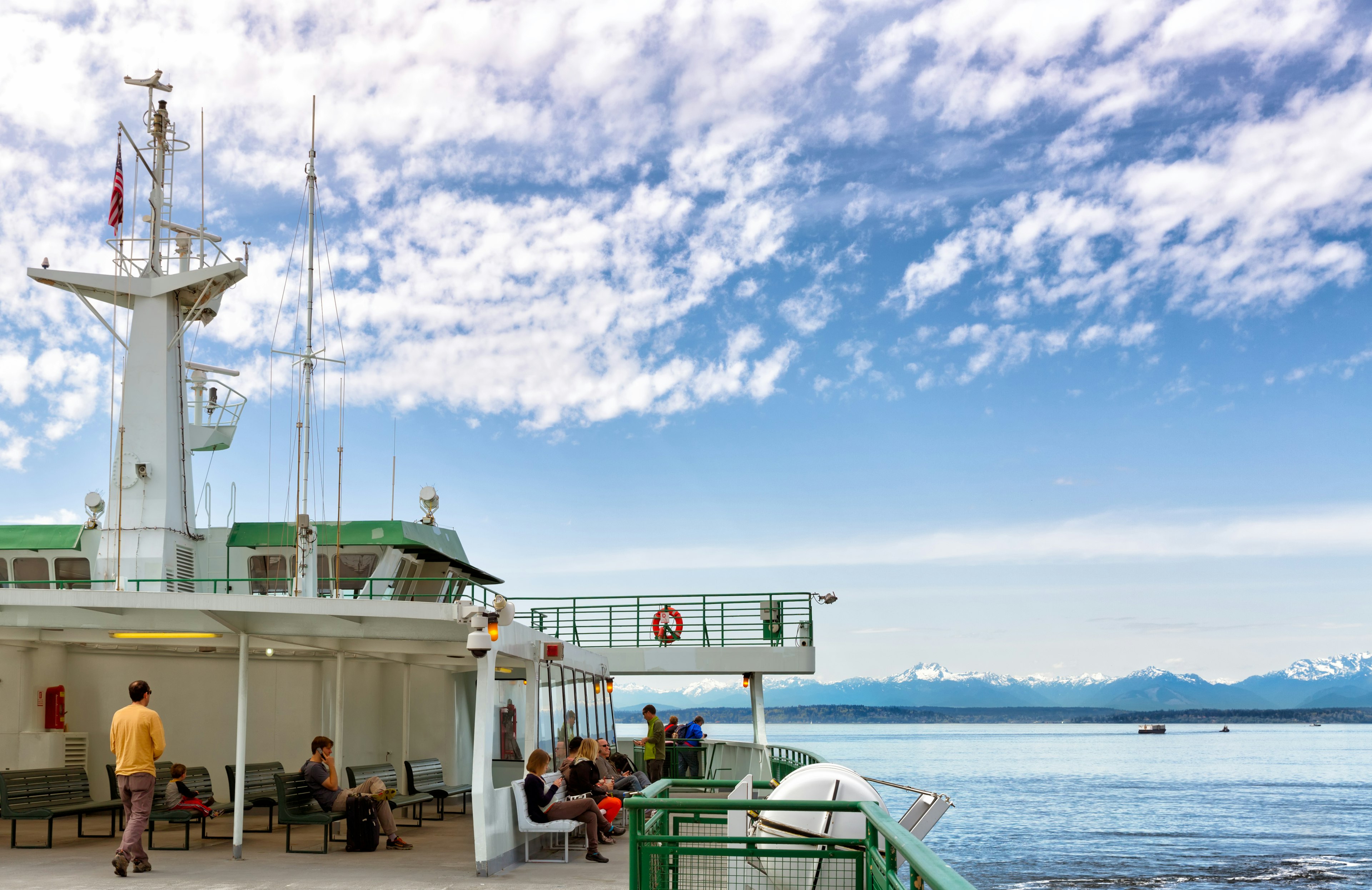 People sit on a ferry as it transports them towards an island