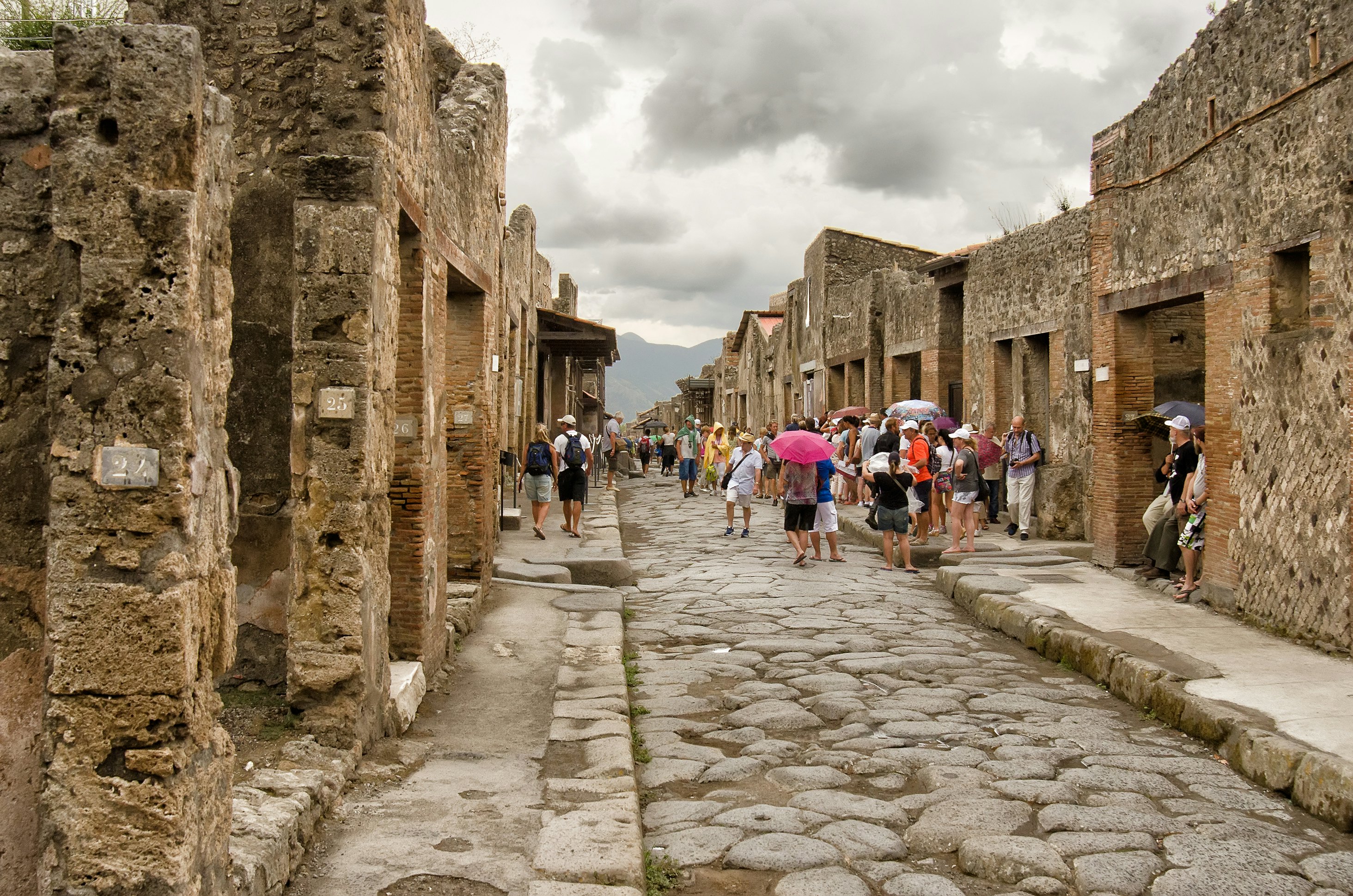 Tourists visit a ruined street in Pompeii, Campania, Italy.