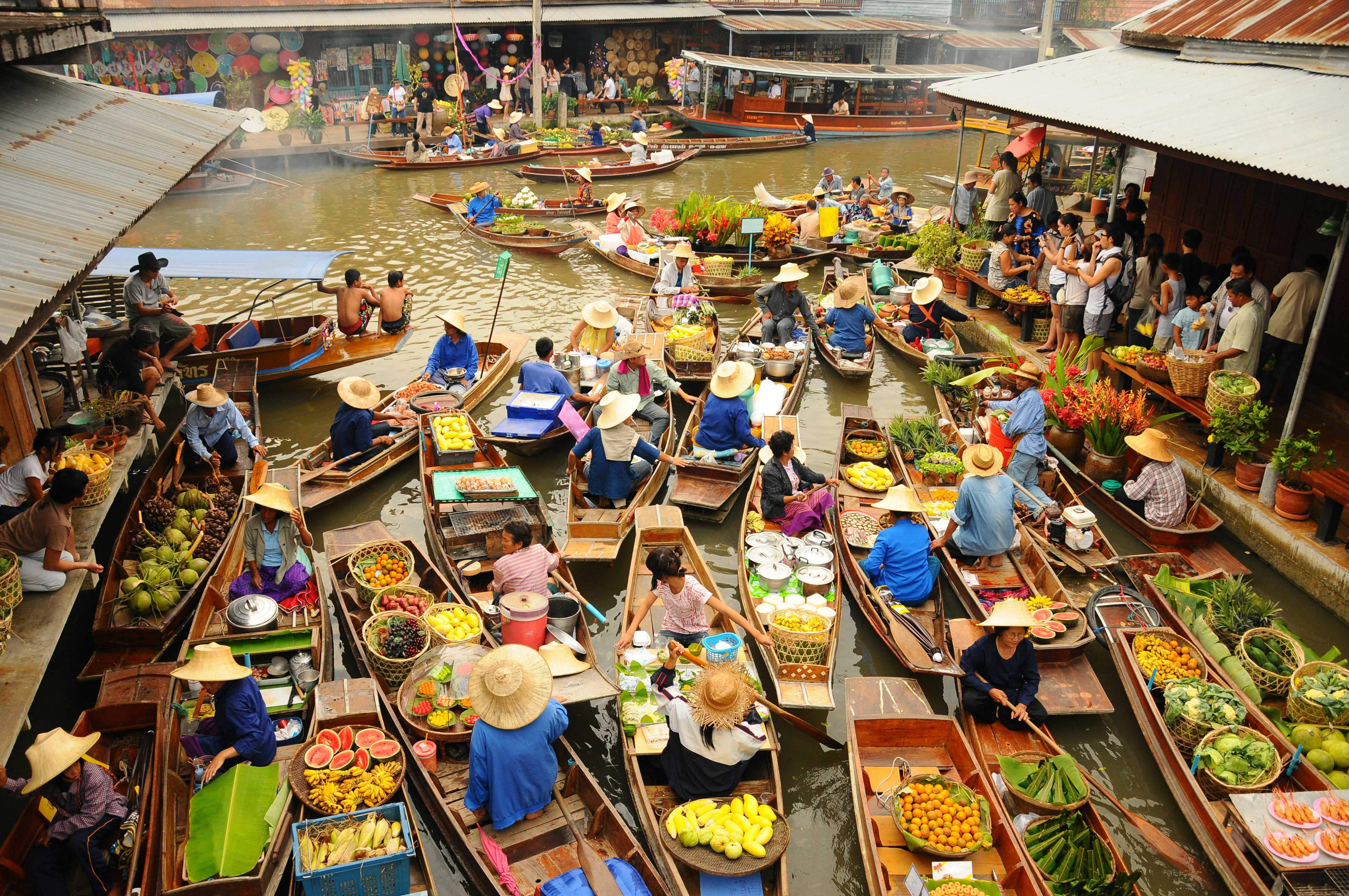 Wooden boats busy ferrying people at Amphawa floating market.