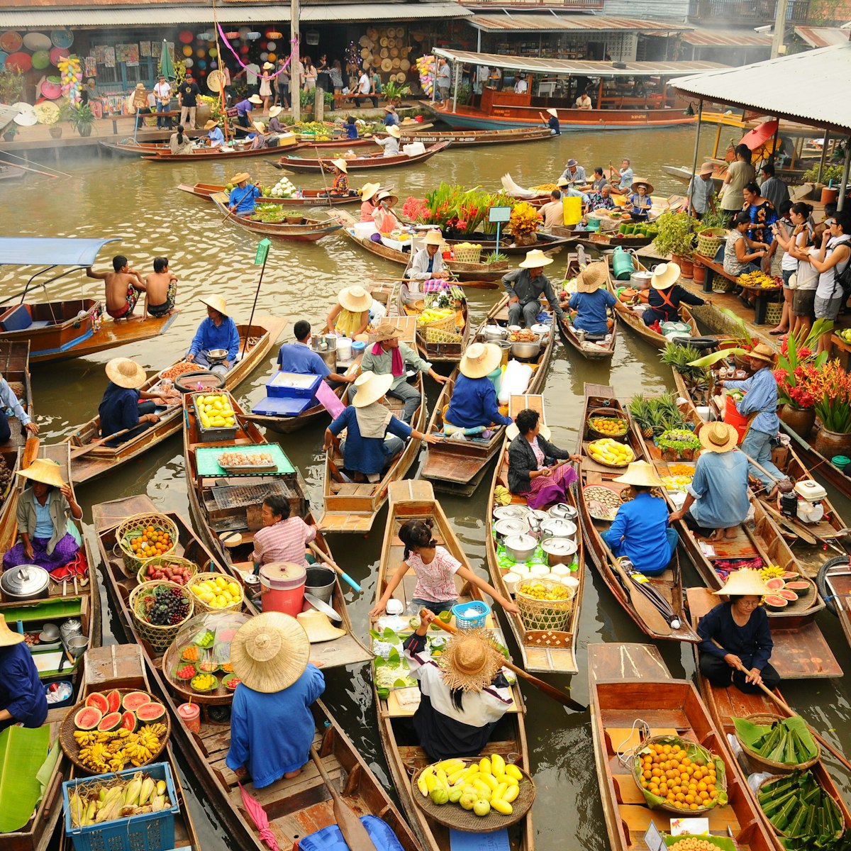 Wooden boats busy ferrying people at Amphawa floating market.