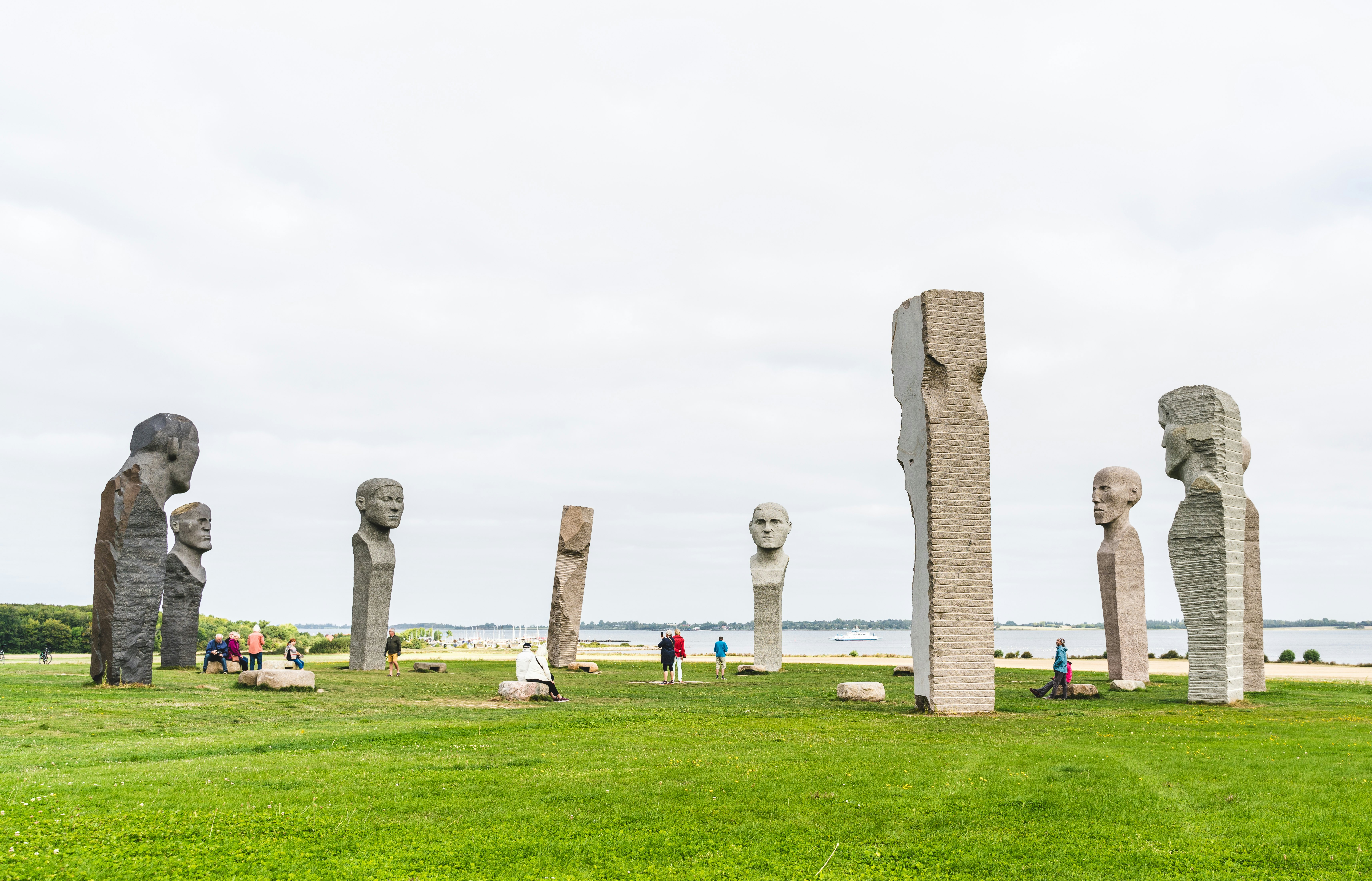 Tourists visiting Dodekalitten, the site of large stone statues on a summers day in Denmark.
