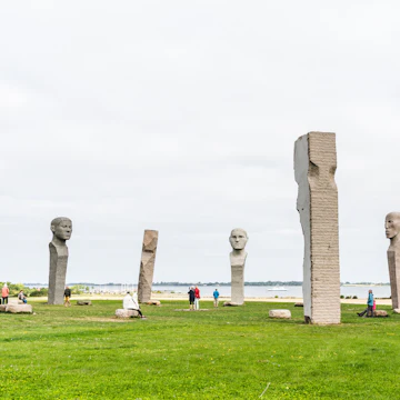 Tourists visiting Dodekalitten, the site of large stone statues on a summers day in Denmark.