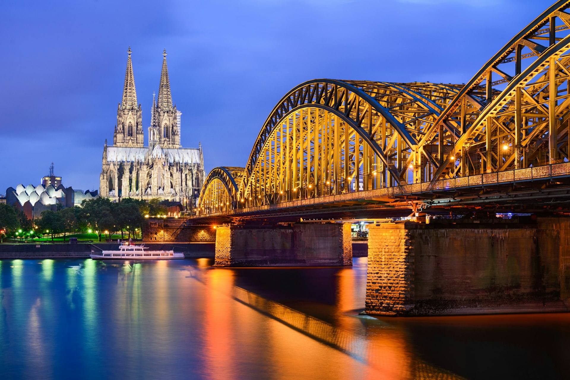 Illuminated view of Cologne Cathedral next to river in Germany 