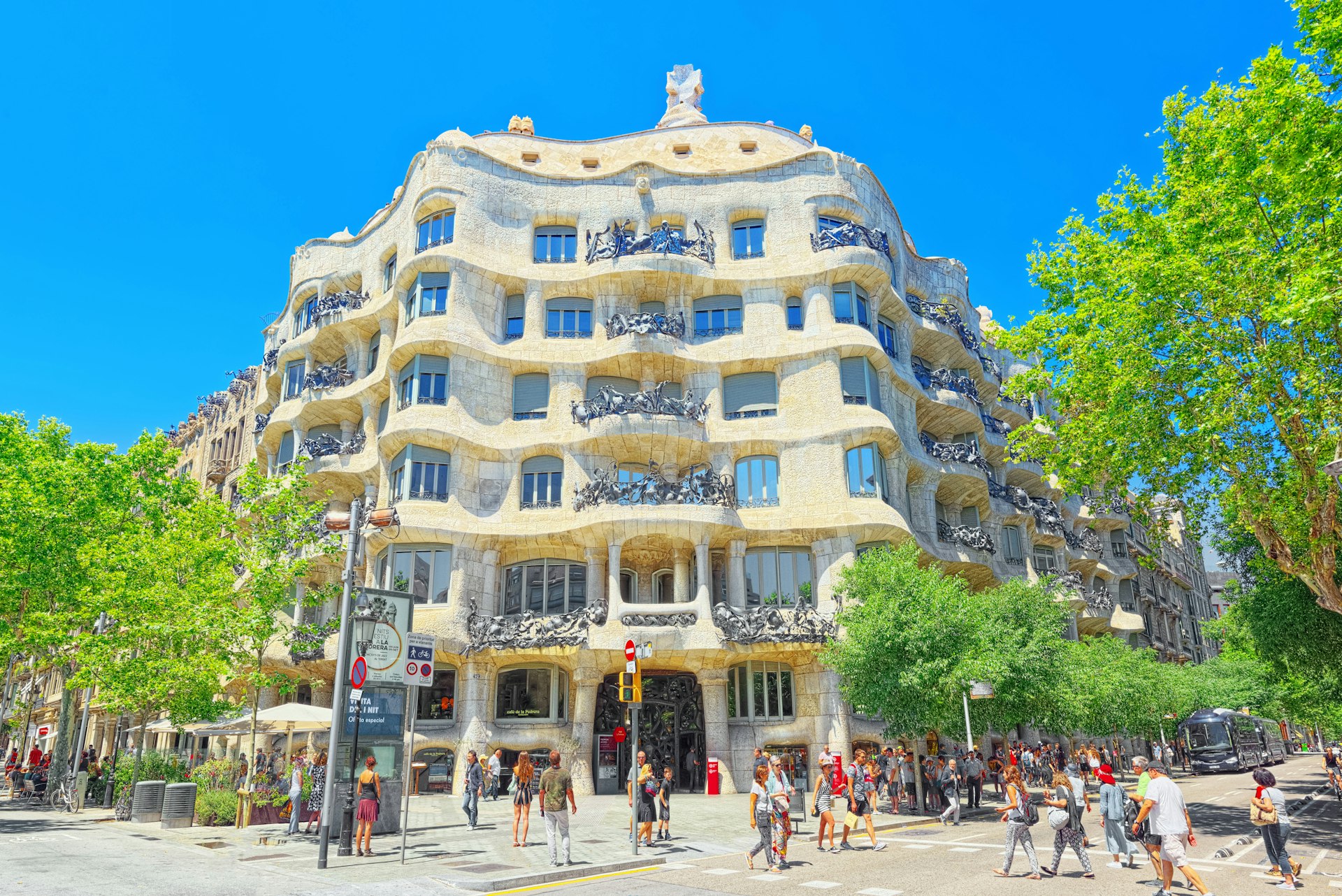 People on the sidewalk in front of Casa Milà, popularly known as La Pedrera, Barcelona, Catalonia, Spain