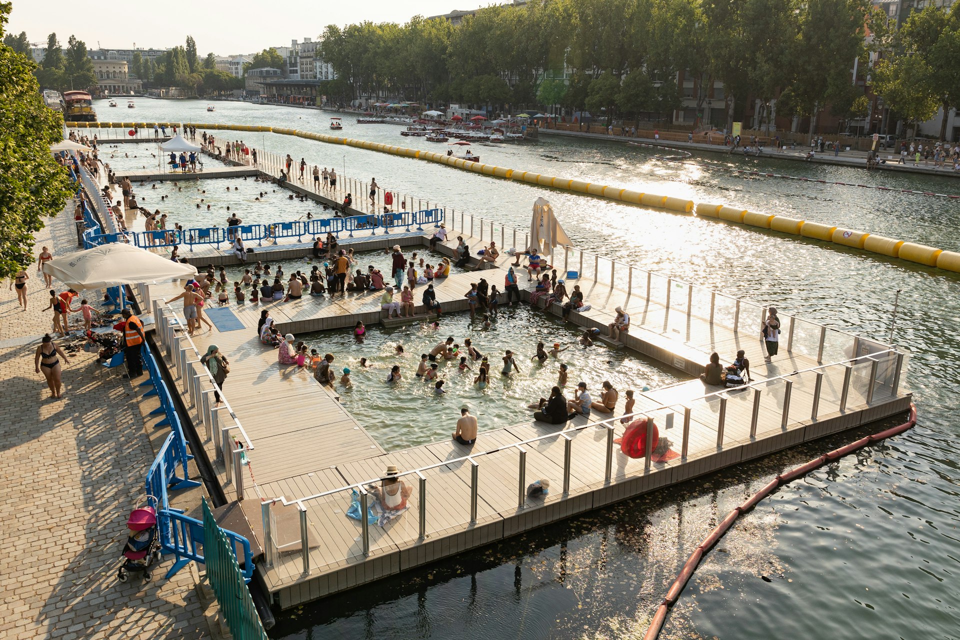 People swim and sit on docks on the largest artificial body of water in Paris