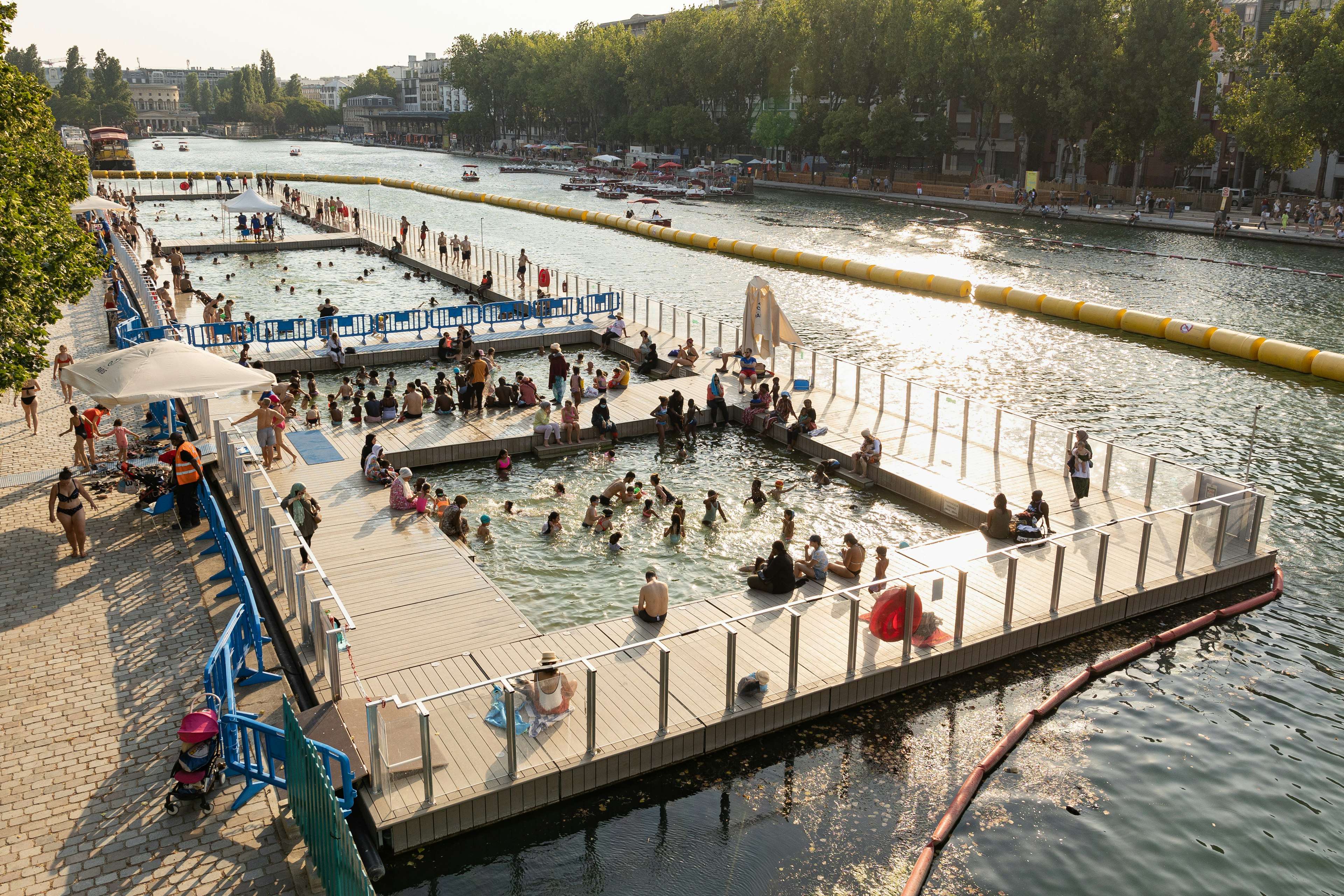 People swim and sit on docks on the largest artificial body of water in Paris