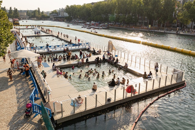 People swim and sit on docks on the largest artificial body of water in Paris