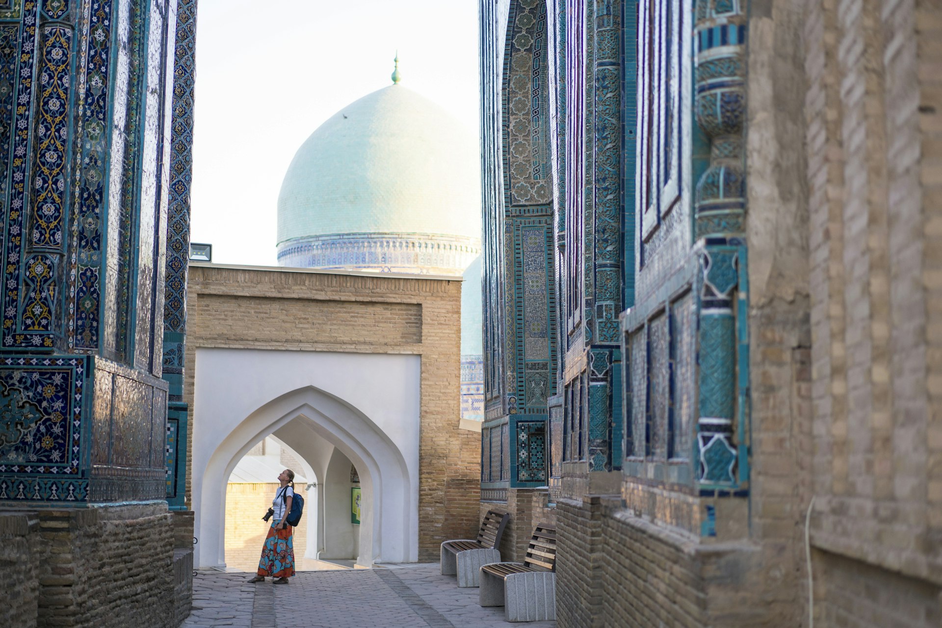 A woman looking up at the memorial buildings of Shah-I-Zinda Mausoleums in Samarkand, Uzbekistan 
