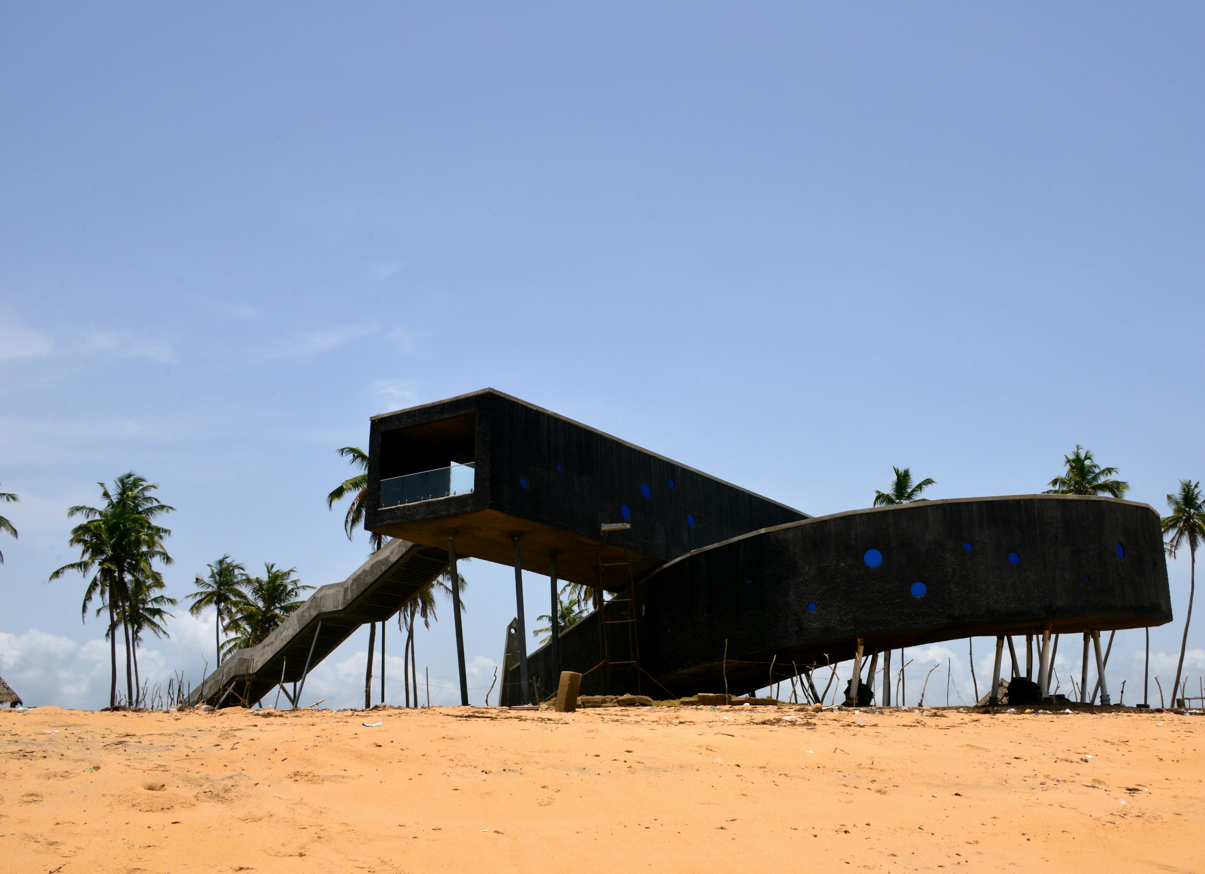 A black elevated walkway/structure on the beach at Badagry, Nigeria, marking the Point of No Return, a slave port on the Atlantic Ocean.