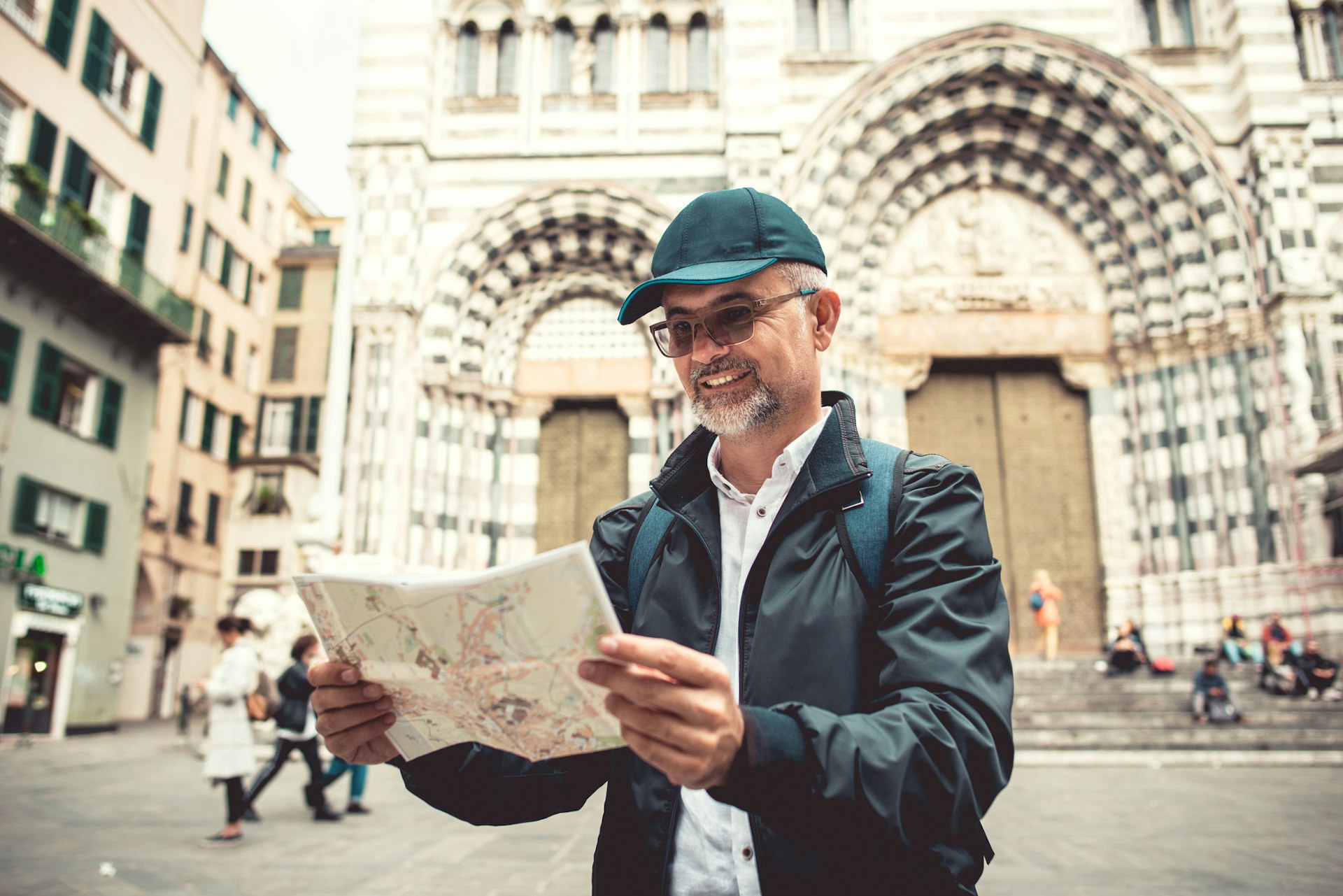 A man reading a map in front of the Cattedrale San Lorenzo in Genoa