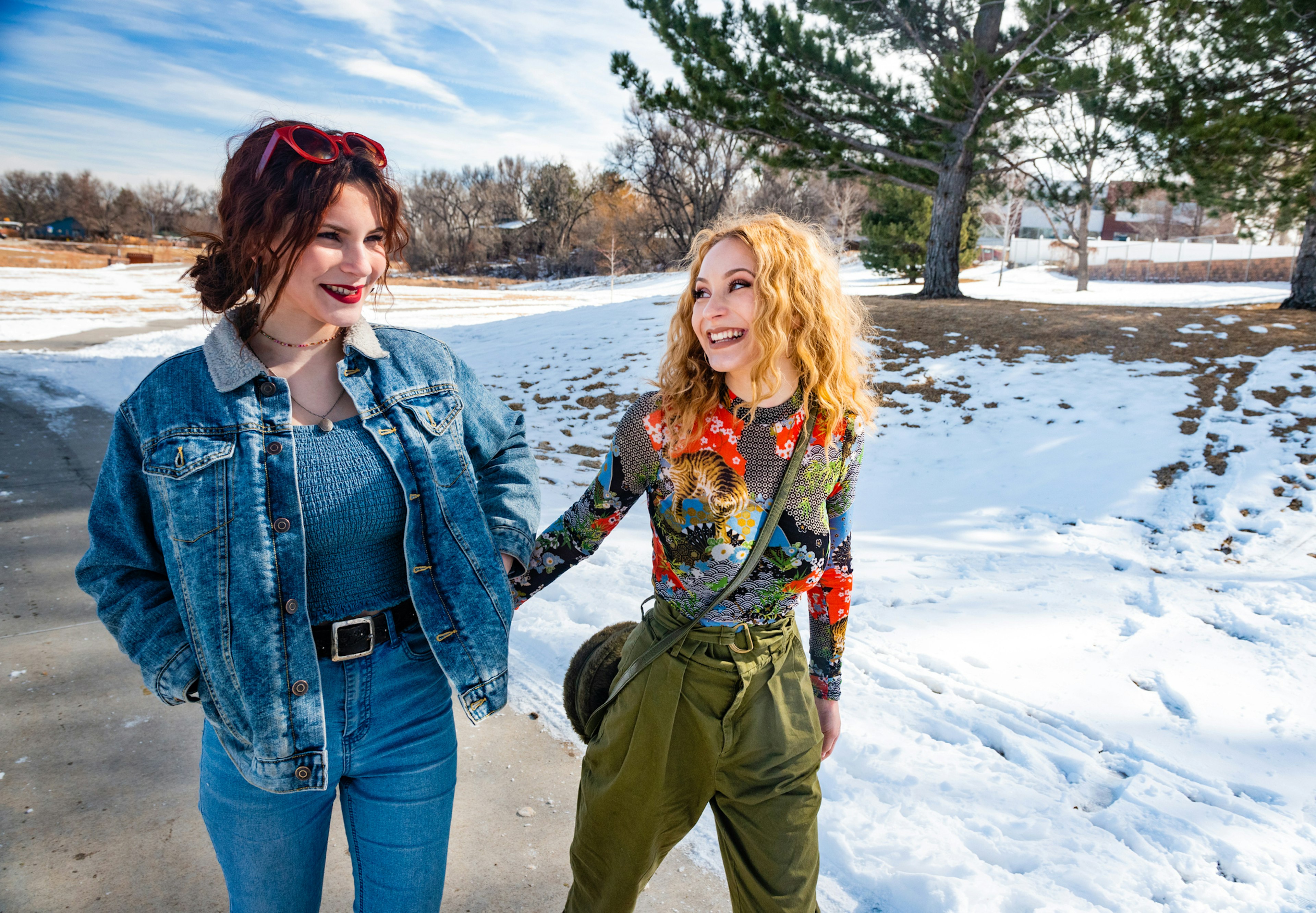 This is a photograph of Hispanic teenager sisters walking outdoors on a sunny winter day in Denver, Colorad