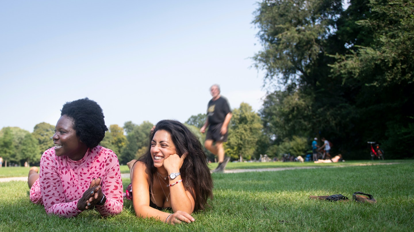 1175754310
Two women lying on the grass in a park in Amsterdam