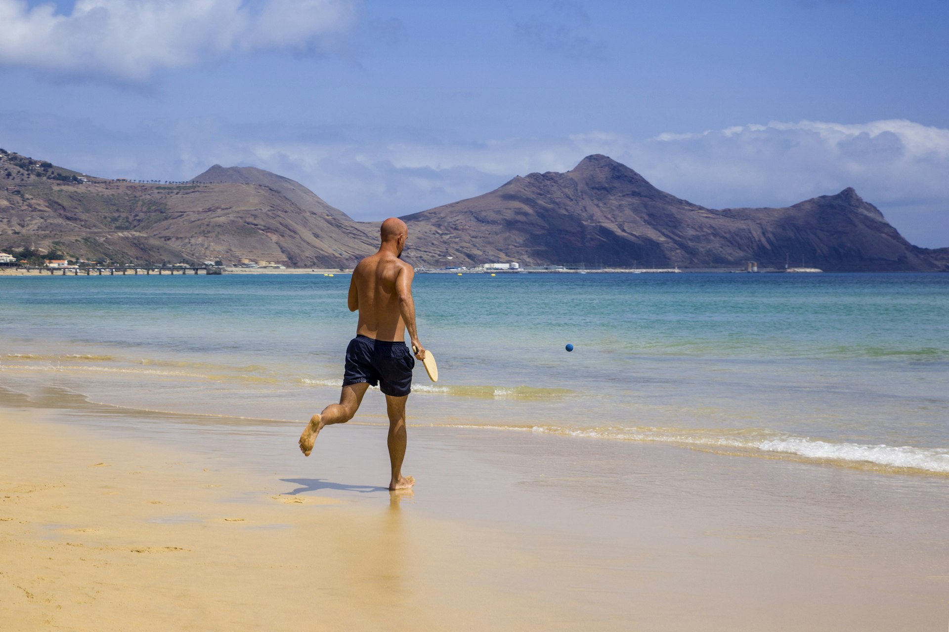 A man running along Porto Santo beach in Madeira