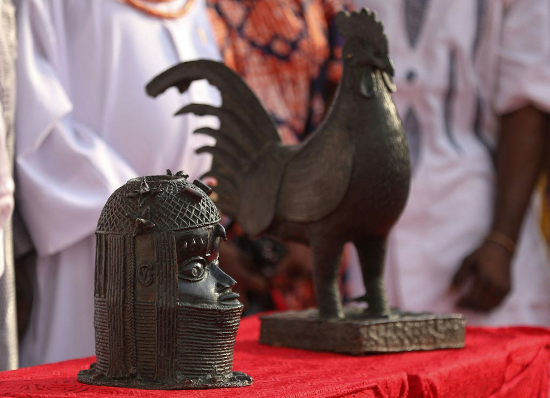 The two artifacts, which include a bronze cockerel and a bust that were looted from Nigeria over 125 years ago by the British military force, are placed on a table inside the Oba of Benin palace where it was looted in Benin City