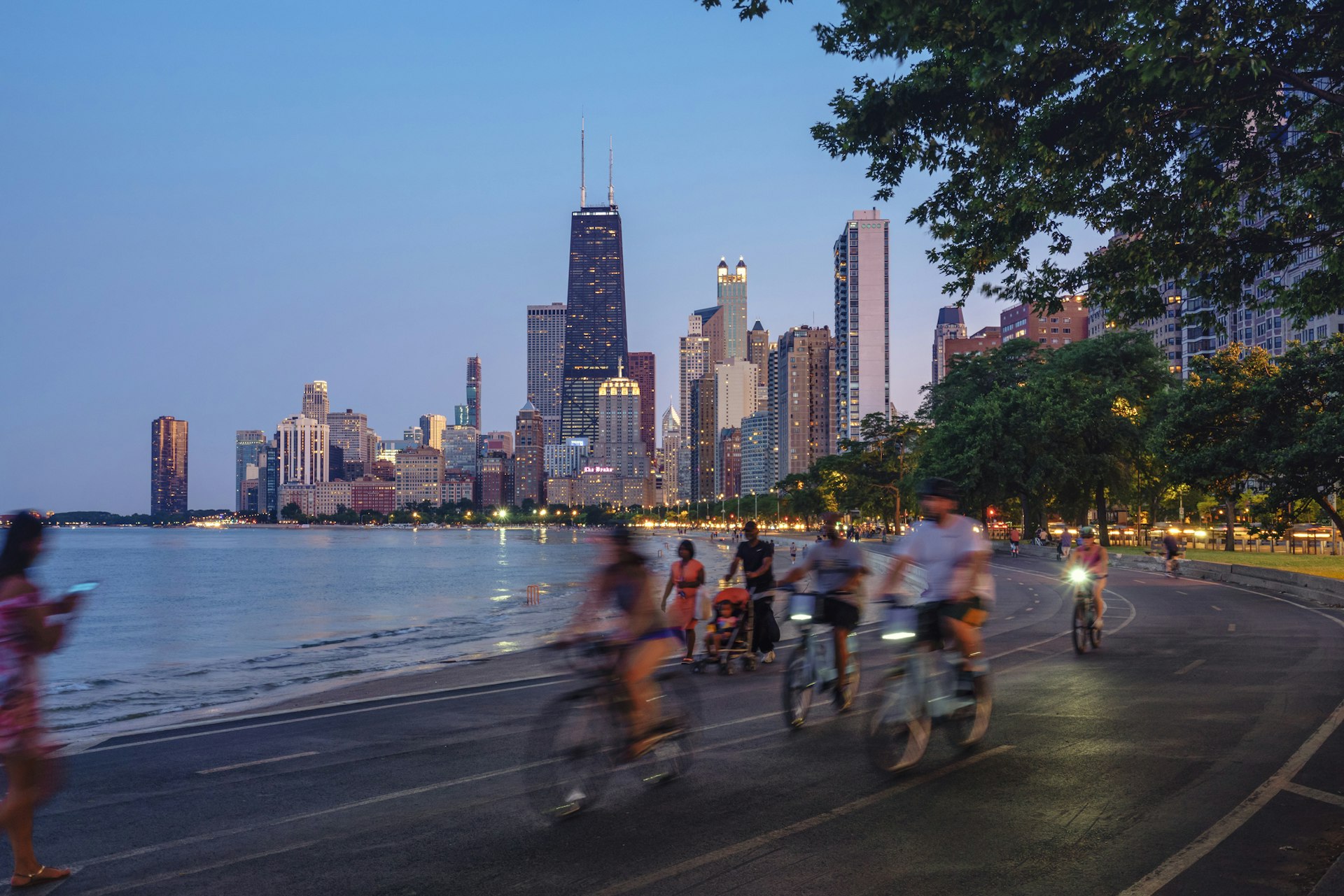 People riding bicycles at night along Lake Michigan, Chicago, Illinois, USA