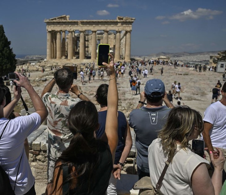 TOPSHOT - Tourists take photos and selfies ifront of the Parthenon Temple during their visit at the Acropolis archaeological site in Athens on June 14, 2023. "The wait and the amount of people that are here are definitely overwhelming," a customer services operator told AFP.World Heritage Watch, a non-governmental organisation which supports UNESCO in protecting and safeguarding sites of international value, notes that the Acropolis currently lacks visitor management plans required under the UN watchdog's World Heritage Convention, to which Greece is a signatory. (Photo by Louisa GOULIAMAKI / AFP) (Photo by LOUISA GOULIAMAKI/AFP via Getty Images)
1258955016
Horizontal