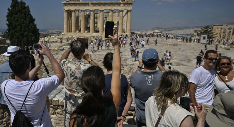 TOPSHOT - Tourists take photos and selfies ifront of the Parthenon Temple during their visit at the Acropolis archaeological site in Athens on June 14, 2023. "The wait and the amount of people that are here are definitely overwhelming," a customer services operator told AFP.World Heritage Watch, a non-governmental organisation which supports UNESCO in protecting and safeguarding sites of international value, notes that the Acropolis currently lacks visitor management plans required under the UN watchdog's World Heritage Convention, to which Greece is a signatory. (Photo by Louisa GOULIAMAKI / AFP) (Photo by LOUISA GOULIAMAKI/AFP via Getty Images)
1258955016
Horizontal