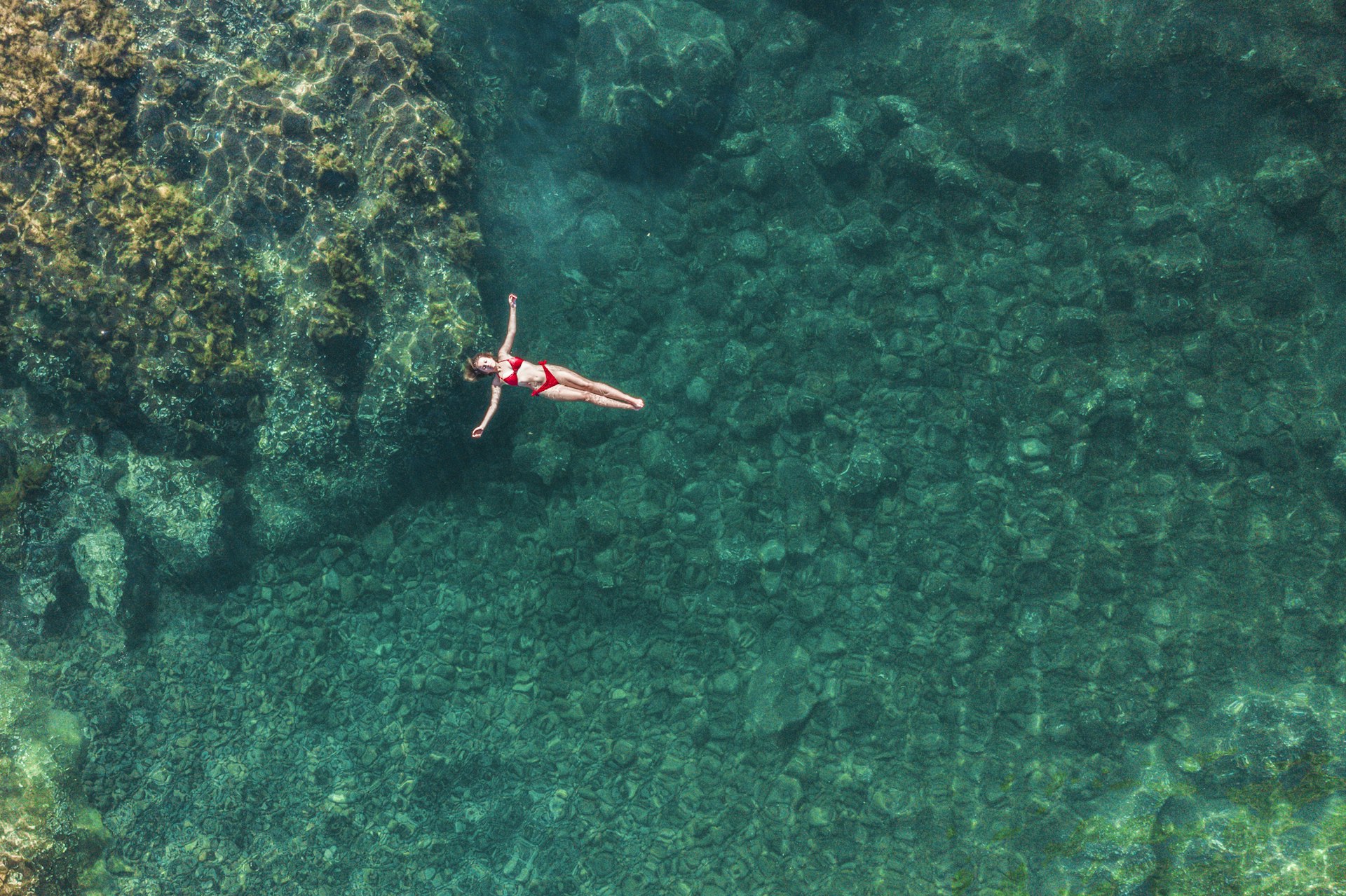 A woman floating in a natural rock pool in Seixal, Madeira