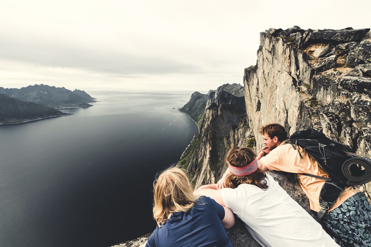 Hikers admiring the fjord standing on top of mount Segla, Senja island, Troms county, Norway
1348951666
Three hikers looking over the edge of a mountain onto the fjord below in Norway