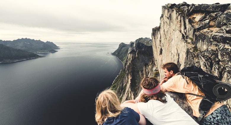 Hikers admiring the fjord standing on top of mount Segla, Senja island, Troms county, Norway
1348951666
Three hikers looking over the edge of a mountain onto the fjord below in Norway