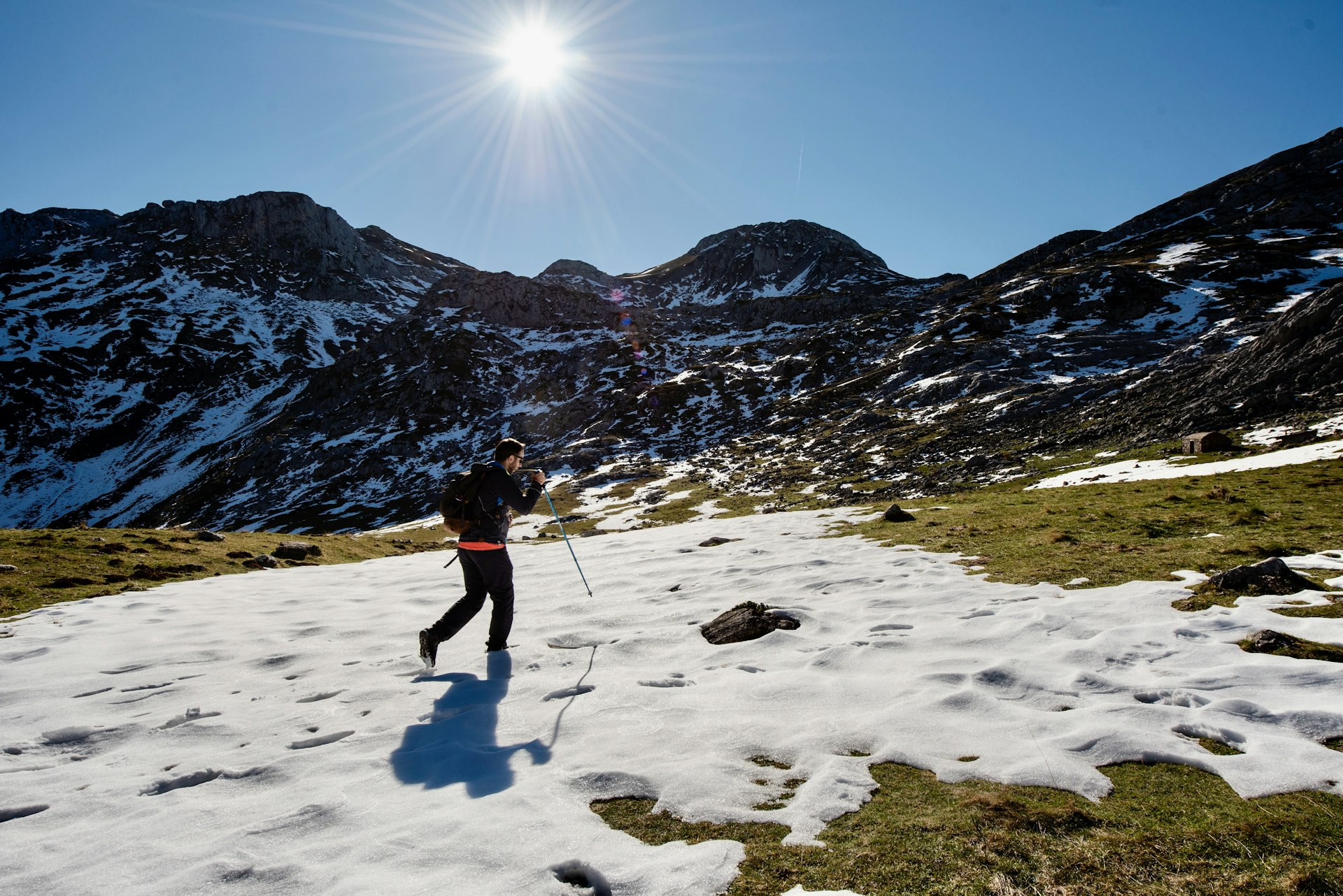 A hiker on a trail with residual snow in Parque Natural de Somiedo, Asturias, Spain