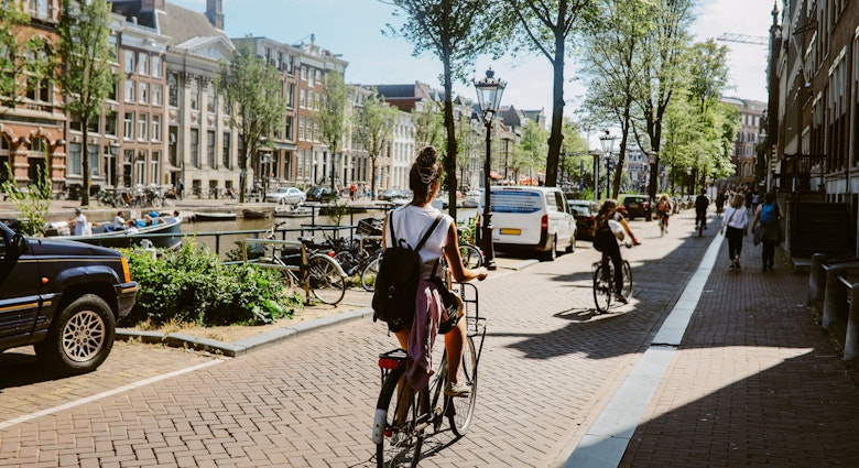 Woman cycling in Amsterdam, commuting or just sightseeing on a bright summer day.
1416056985